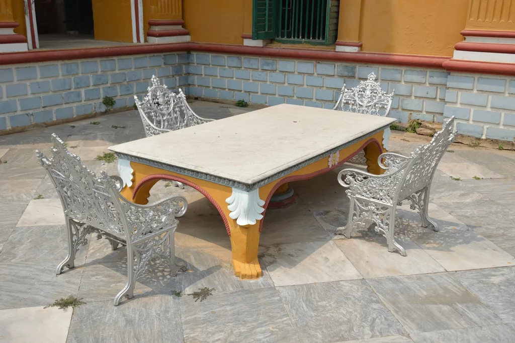Table et fauteuils de jardin en fonte sur une terrasse